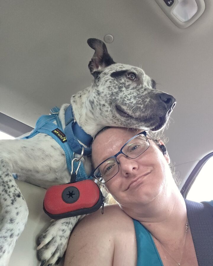 Taea in the car on a day out, with a spotted dog resting his head on hers